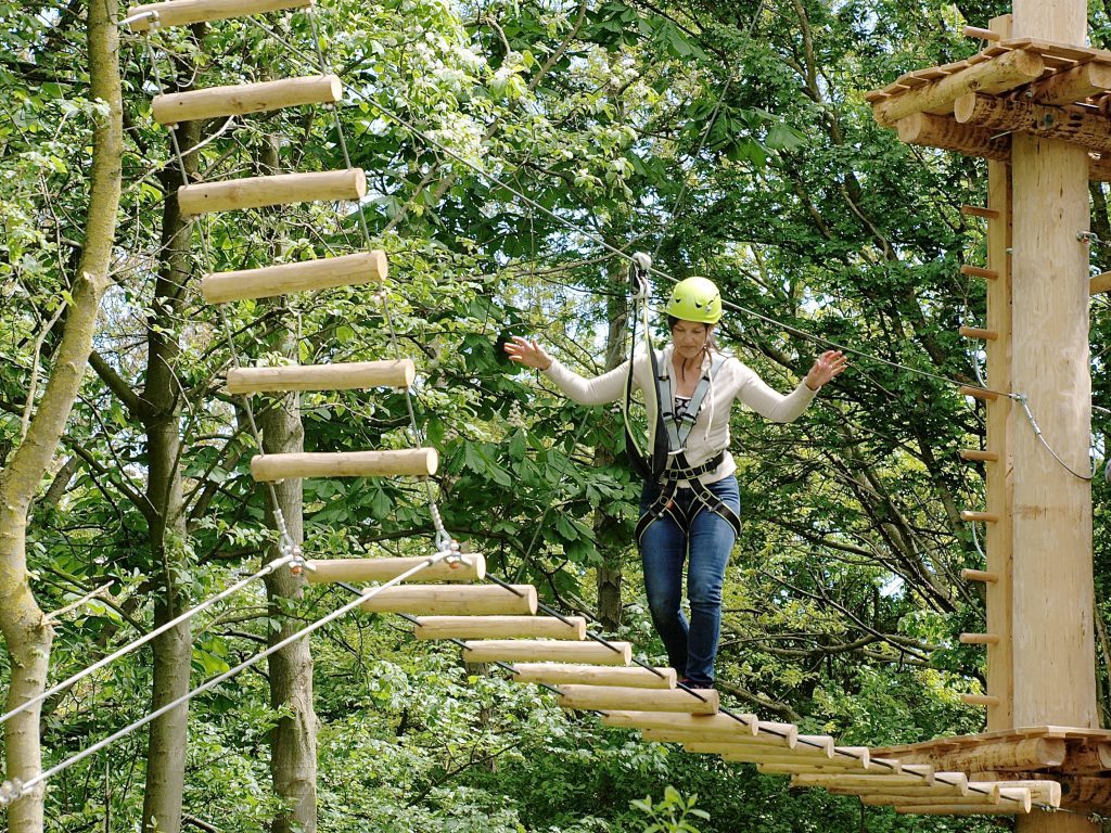 Mevrouw onderweg naar de 12 meter in klimpark Streekbos.